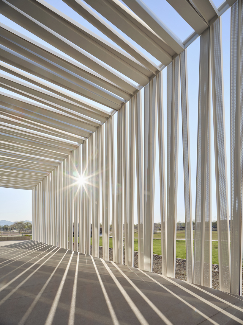 perforated metallic canopy filters light within richärd kennedy architects' asante public library