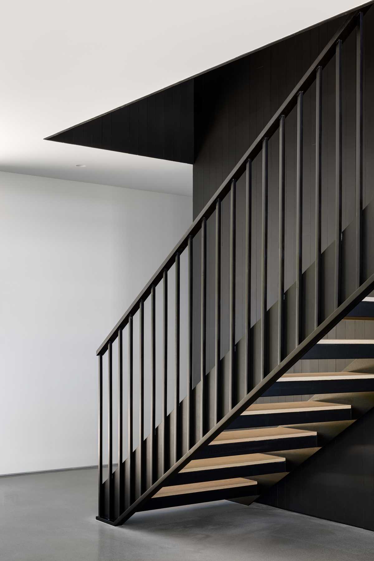 A floating staircase and cedar-clad volume define the separation between public and private spaces in this home.