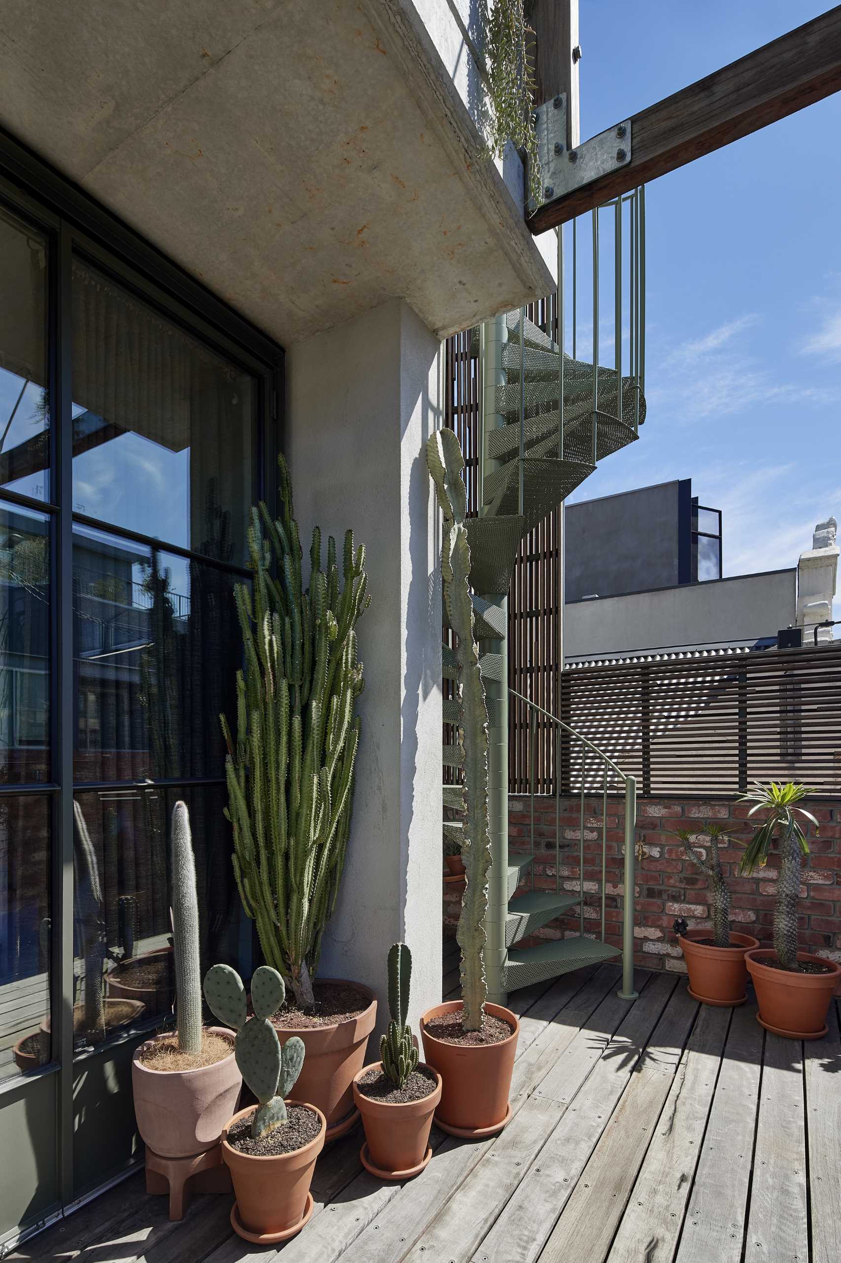 The rooftop terrace is the crown of the townhome, accessed by a spiral stair visible from the street. 