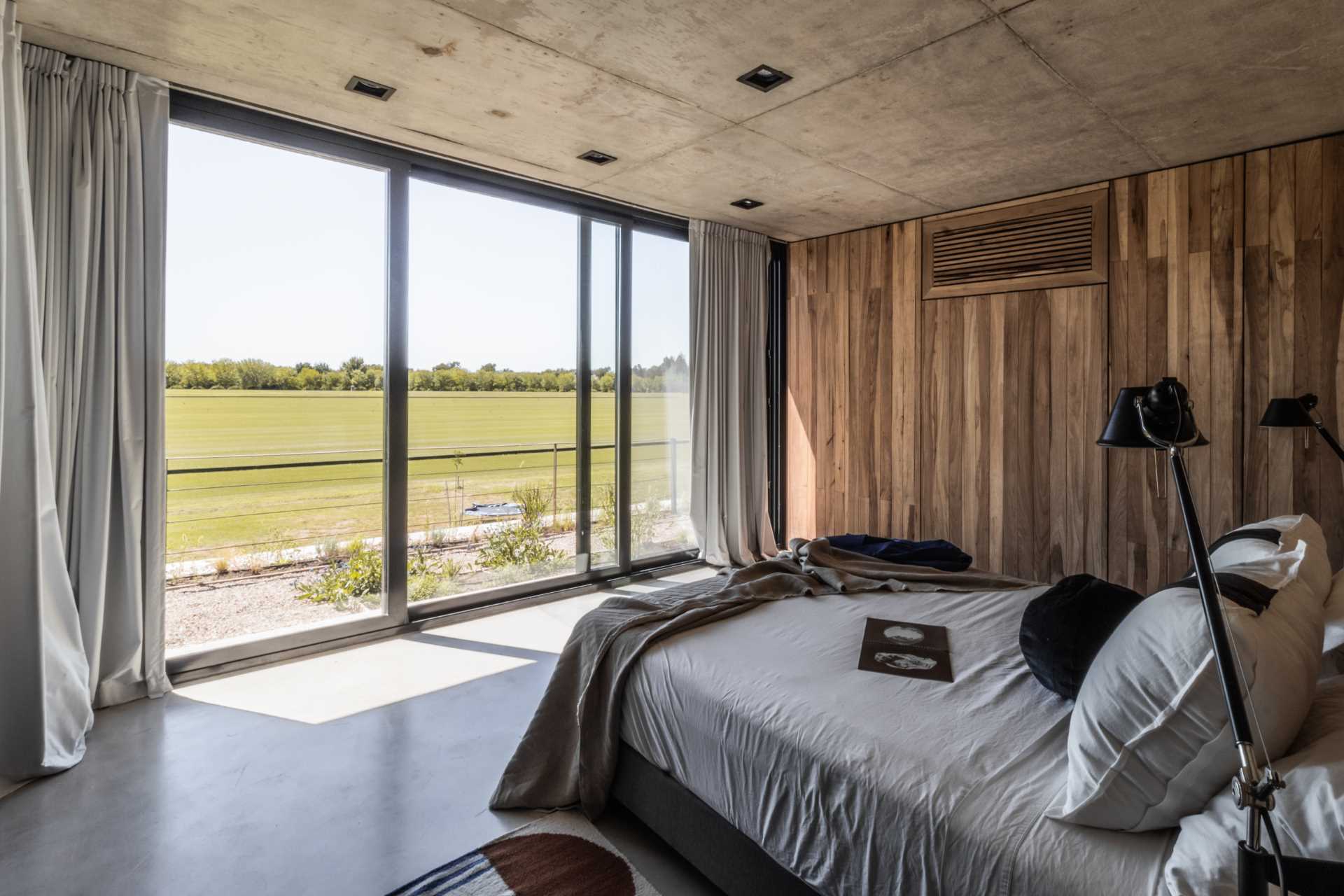 A modern bedroom with a material palette of concrete and wood.