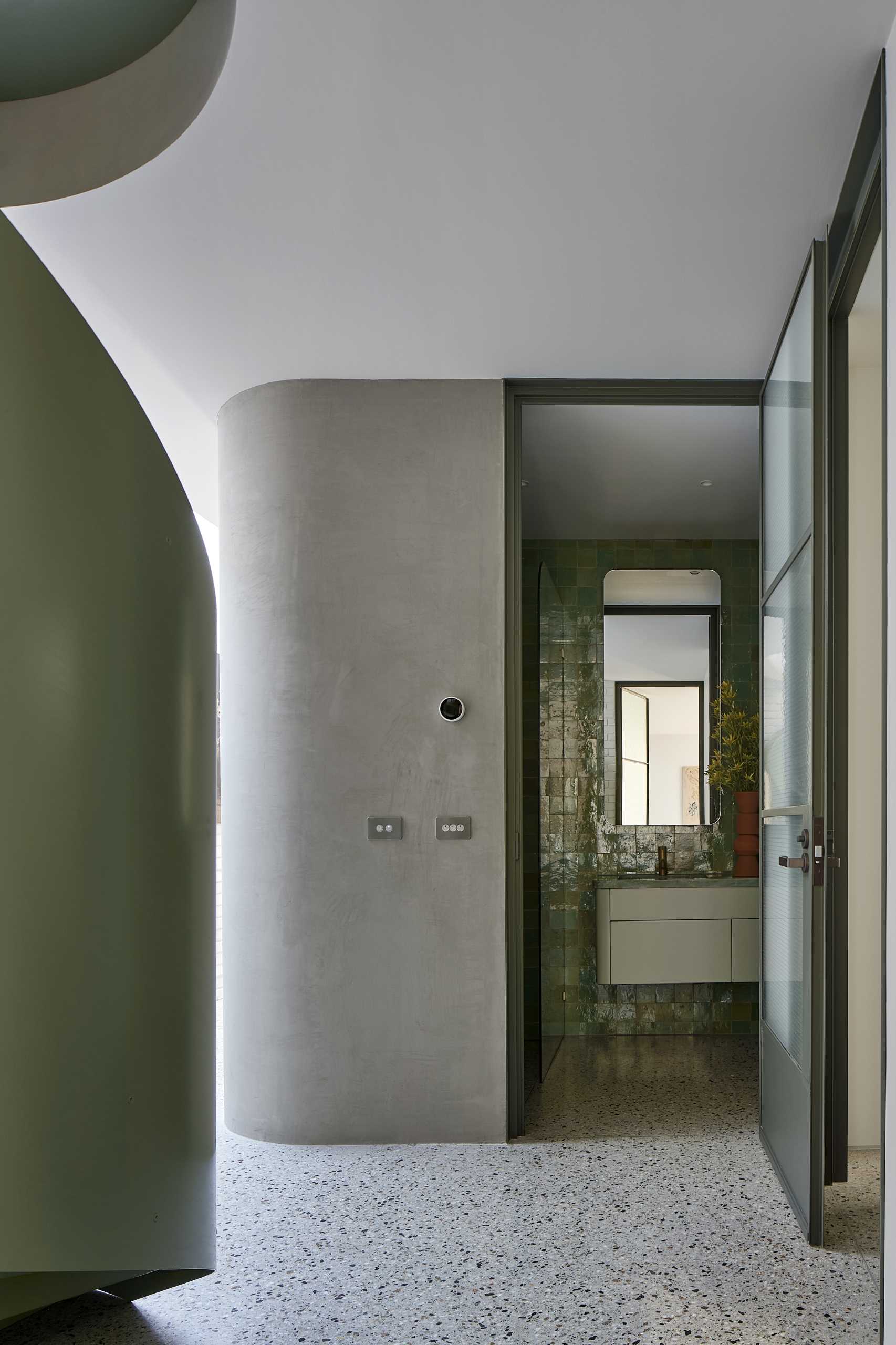 A modern bathroom with blue-green handmade tiles.