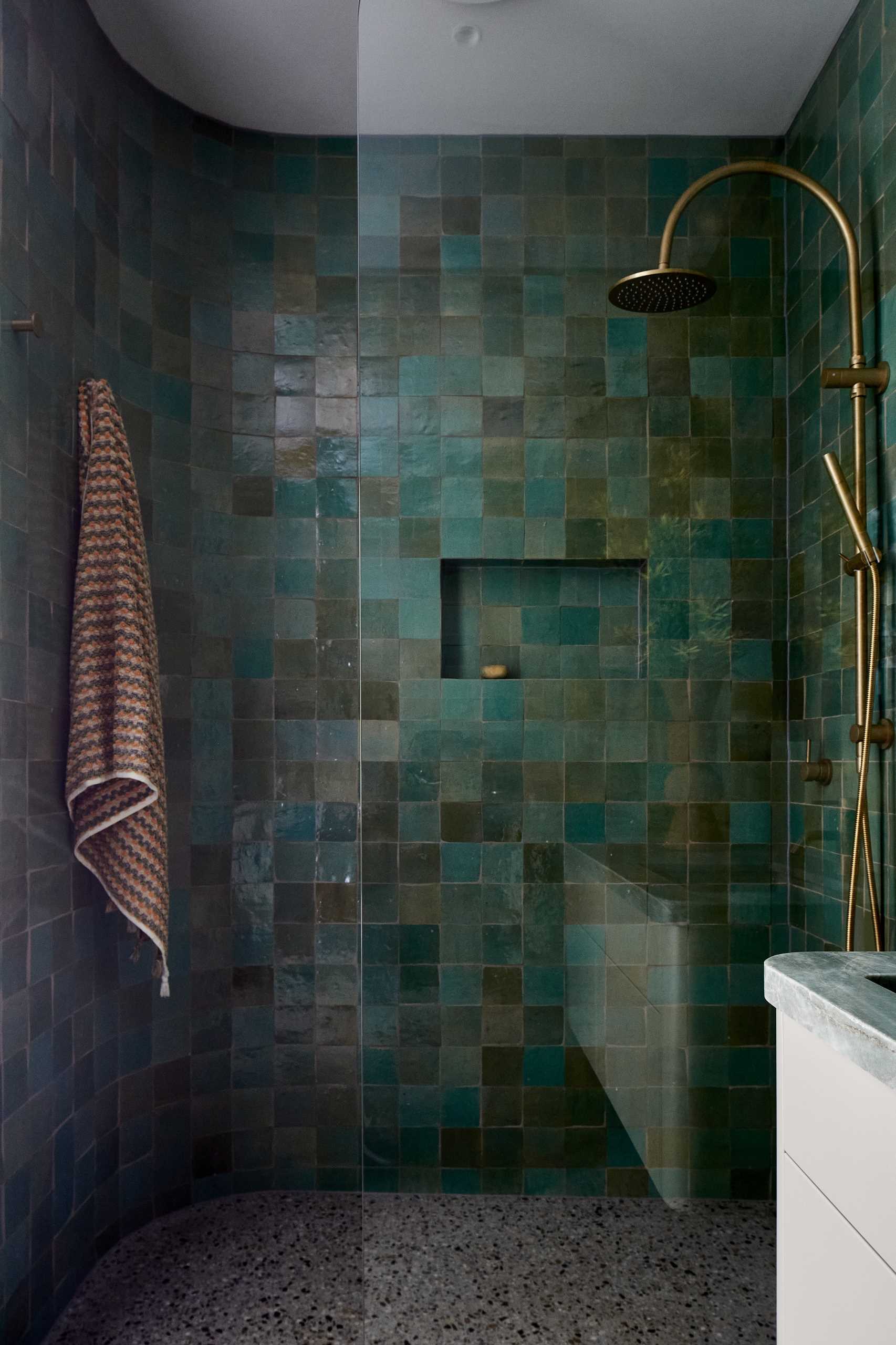 A modern bathroom with blue-green handmade tiles.