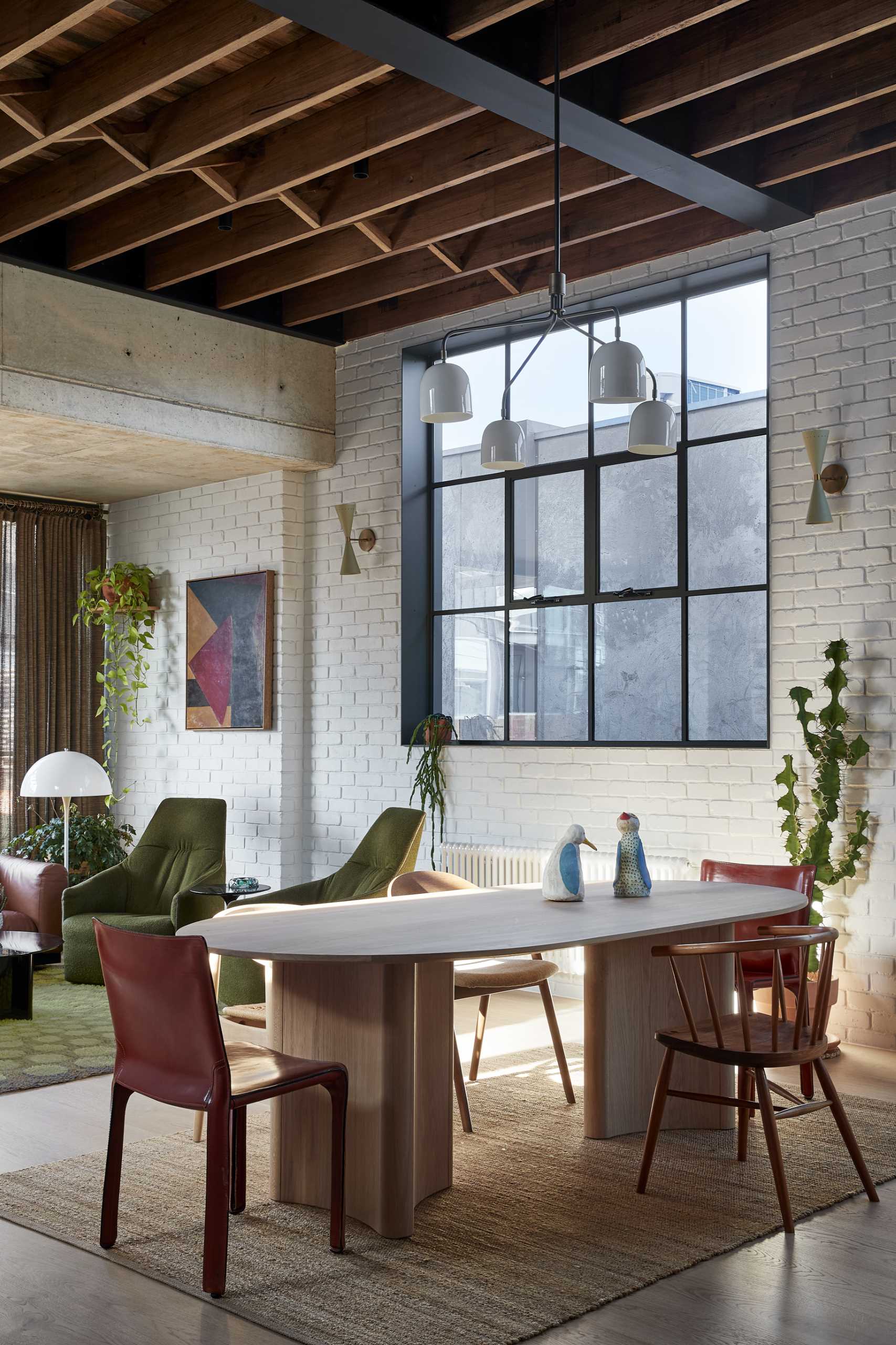 The dining area, with its wood table and chairs, separates the living room from the kitchen.