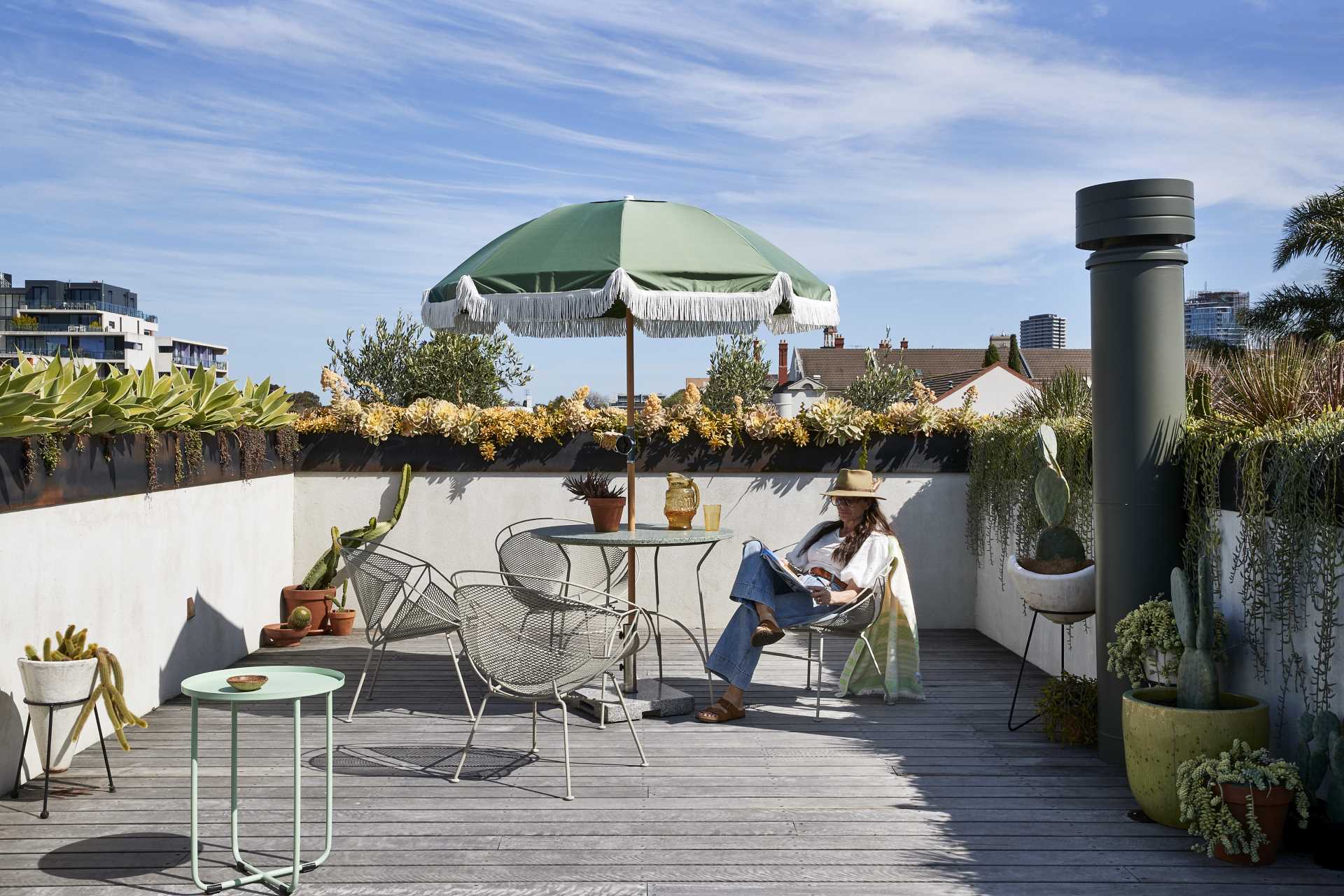 A rooftop terrace lined with steel-topped planter boxes, also includes a small pool and outdoor shower.