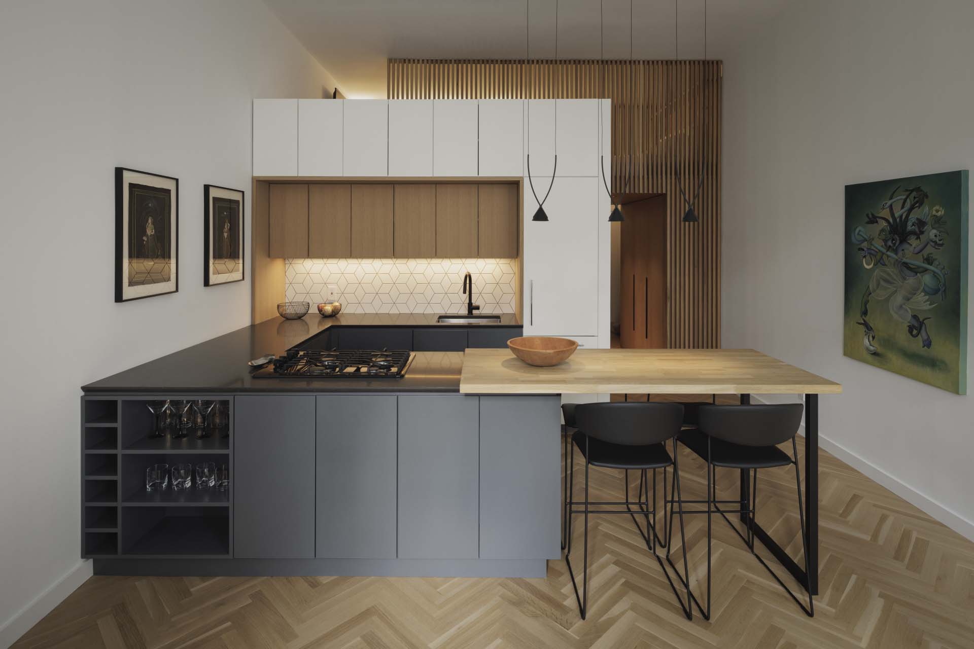 A modern kitchen with dark grey and wood cabinets.