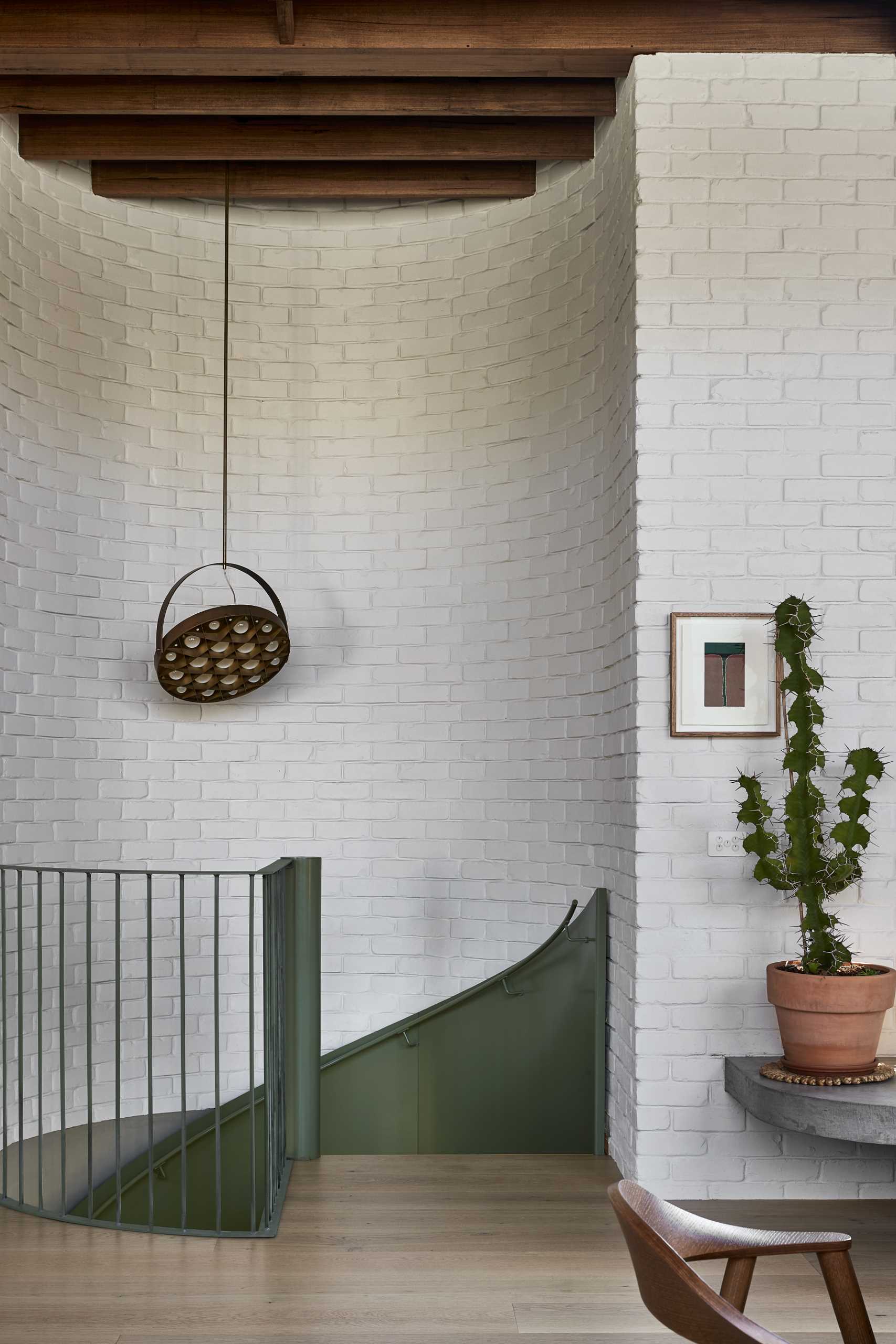 A green spiral staircase travels from the entry level to the main social areas of the home.